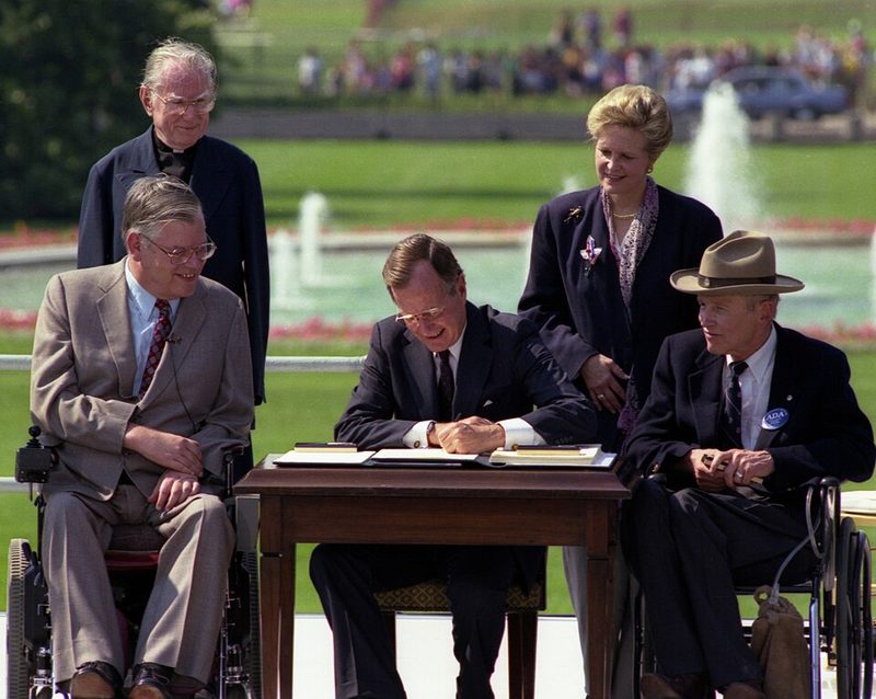 President George H. W. Bush signing the Americans with Disabilities Act on the White House lawn, 1990