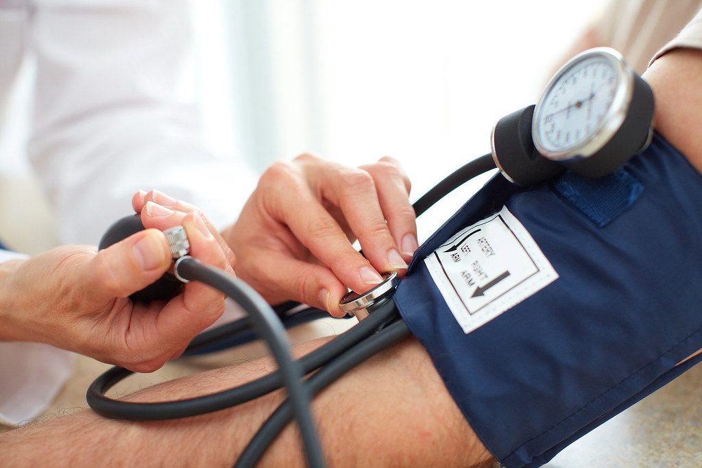A blood pressure cuff and gauge on an arm